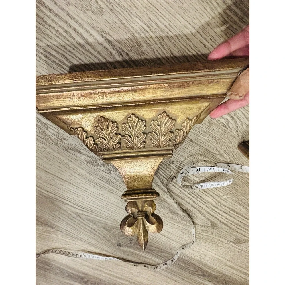 Vintage gold-toned decorative wall shelves with floral motifs.